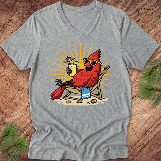 Gray t-shirt with a cardinal wearing sunglasses and a hat, holding a drink, on a wooden surface.