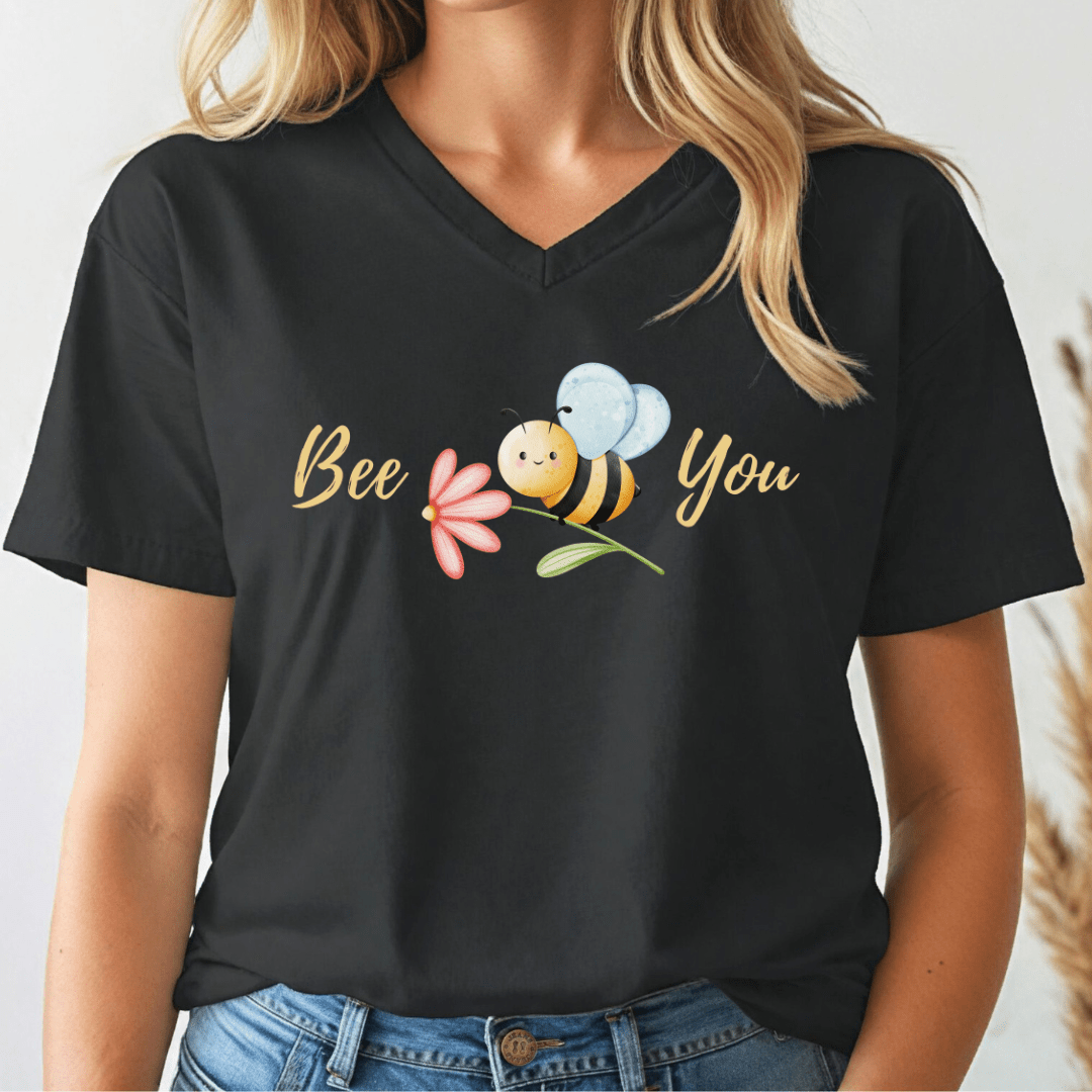 Black v-neck tshirt with a cute bee and the text, "Bee You" worn by a woman.