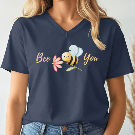 Navy blue v-neck tshirt with a cute bee and the text, "Bee You" worn by a woman.