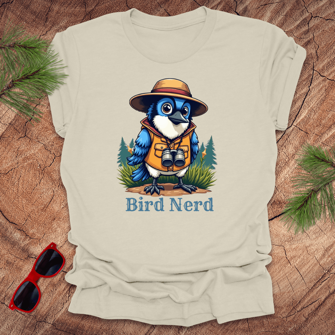 Beige t-shirt with an animated blue jay in birdwatching gear with "bird nerd" text on a wood background.