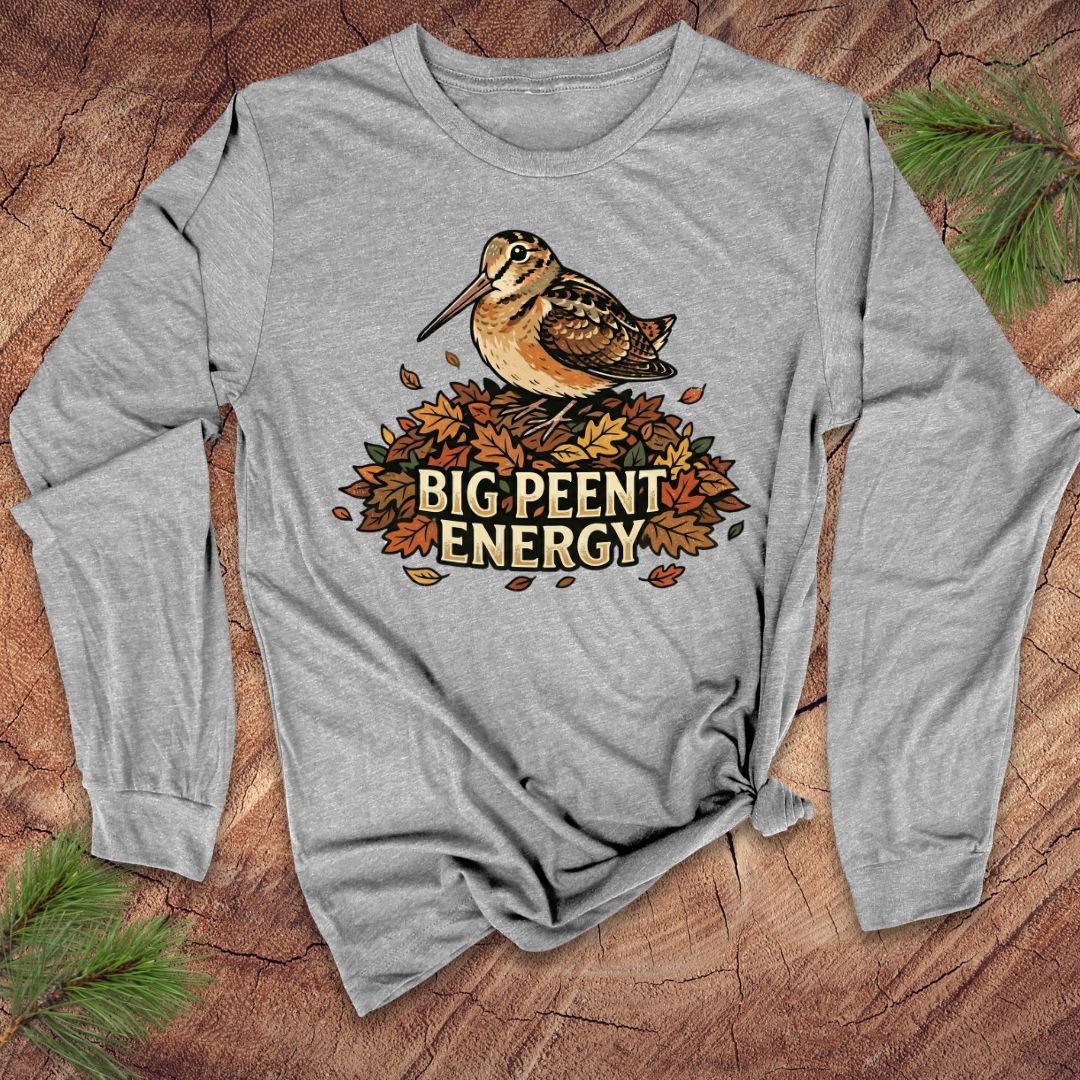 Light gray long-sleeve shirt with a woodcock graphic and 'BIG PEENT ENERGY' text on a wooden surface.