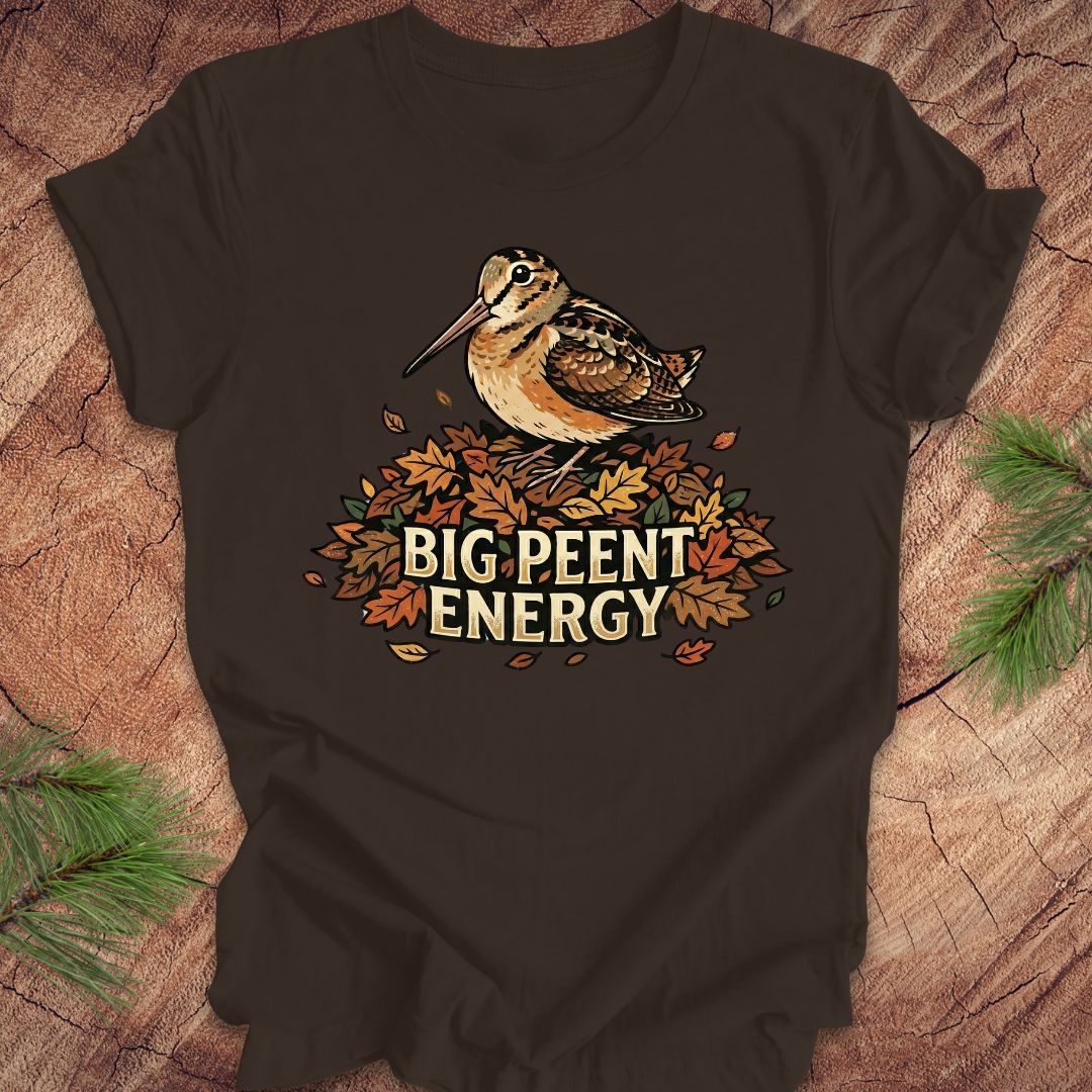 Brown t-shirt with a woodcock graphic and 'BIG PEENT ENERGY' text on a wooden surface.