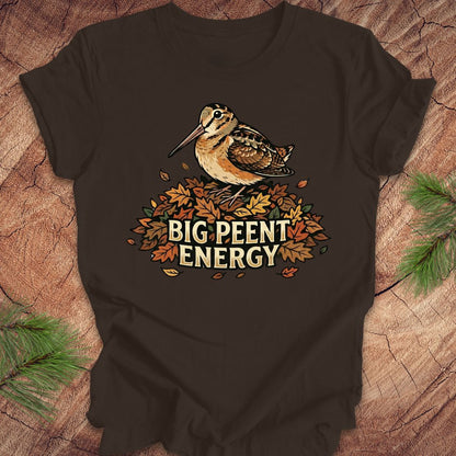 Brown t-shirt with a woodcock graphic and 'BIG PEENT ENERGY' text on a wooden surface.