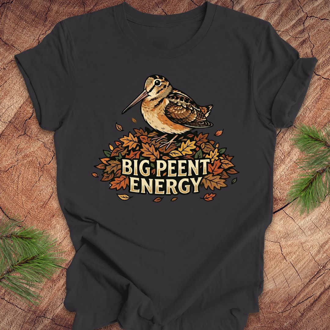 Dark gray t-shirt with a woodcock graphic and 'BIG PEENT ENERGY' text on a wooden surface.