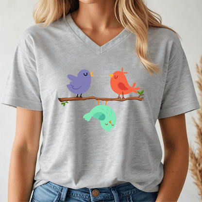 Person wearing a gray t-shirt with colorful birds on a branch design.