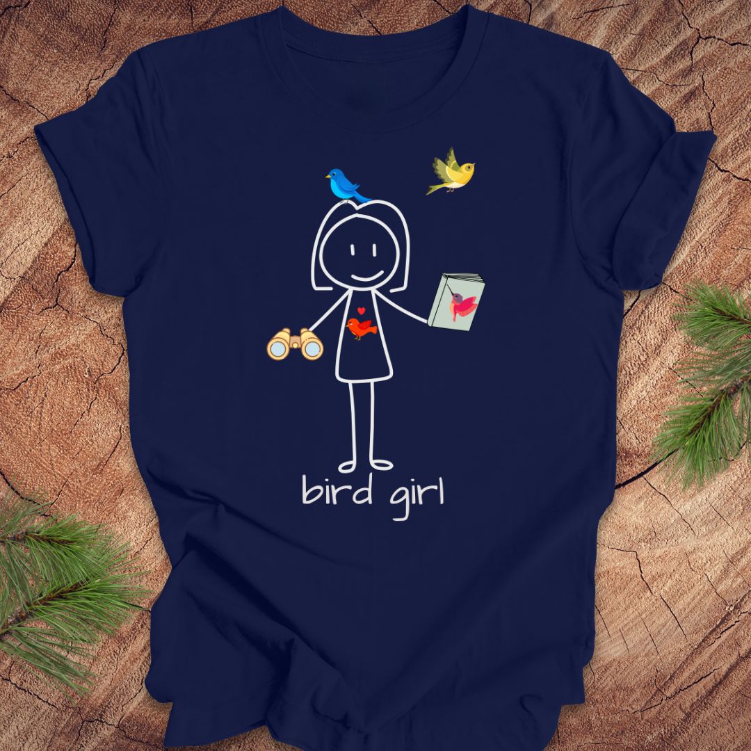 Navy blue t-shirt with a stick figure design labeled 'bird girl' on a wooden surface.