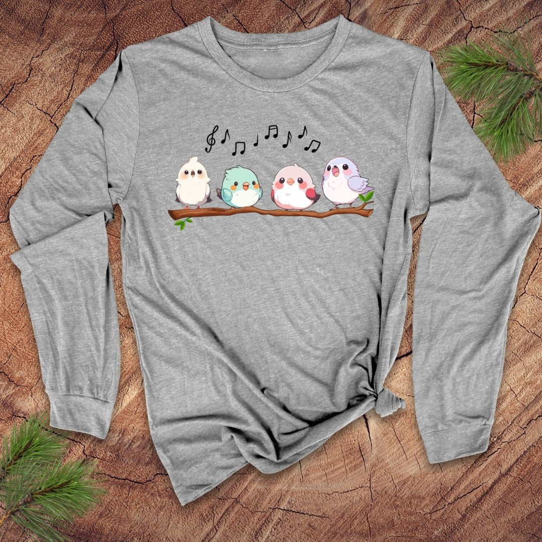 Gray long sleeve t-shirt with four cartoon birds on a branch with musical notes over them, on a wooden background.