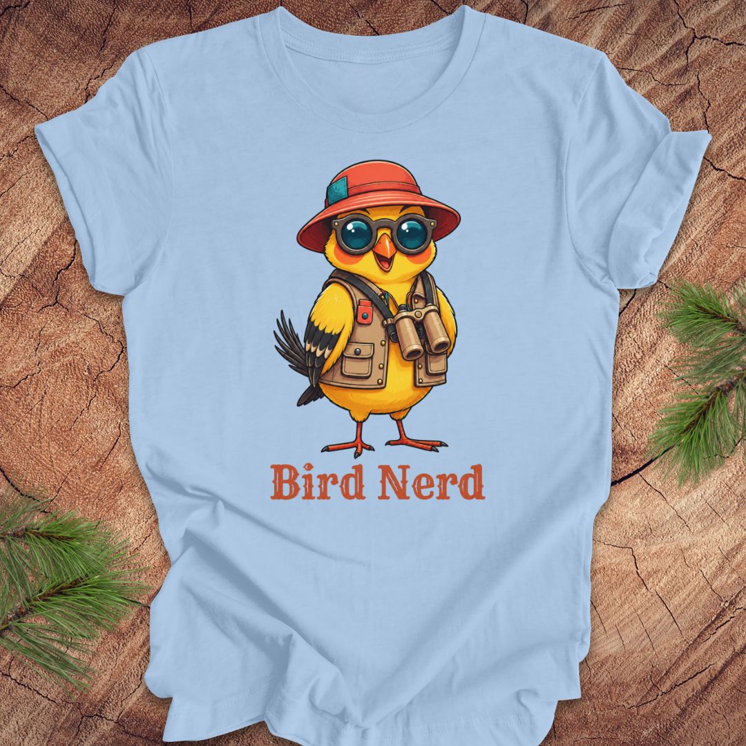 Light blue t-shirt with a cartoon bird wearing a hat and sunglasses, and the text 'Bird Nerd' on a wooden surface.
