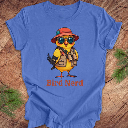 Blue t-shirt with a cartoon bird wearing a hat and sunglasses on a wooden surface.