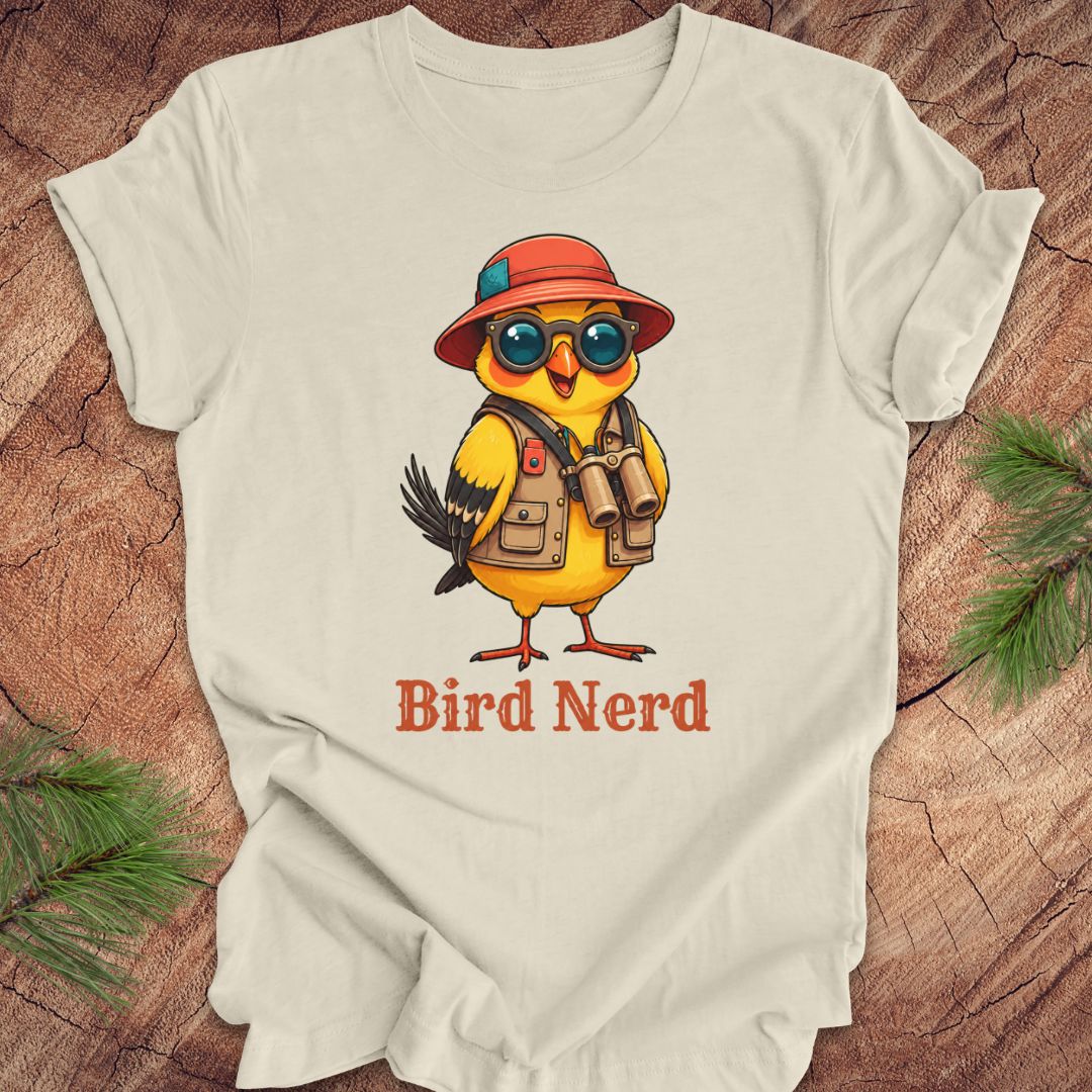 Beige t-shirt with a cartoon bird wearing a hat and sunglasses, labeled 'Bird Nerd', on a wooden surface.