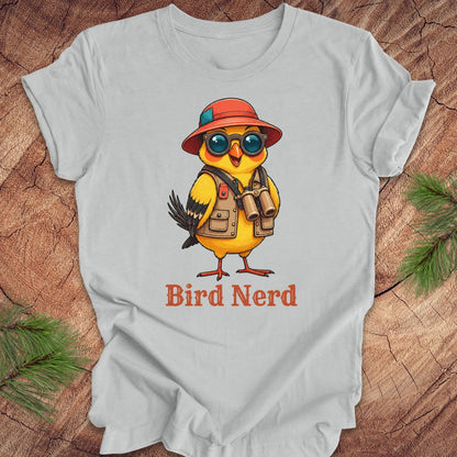 Gray t-shirt with a cartoon bird wearing a hat and sunglasses, labeled 'Bird Nerd', on a wooden surface.