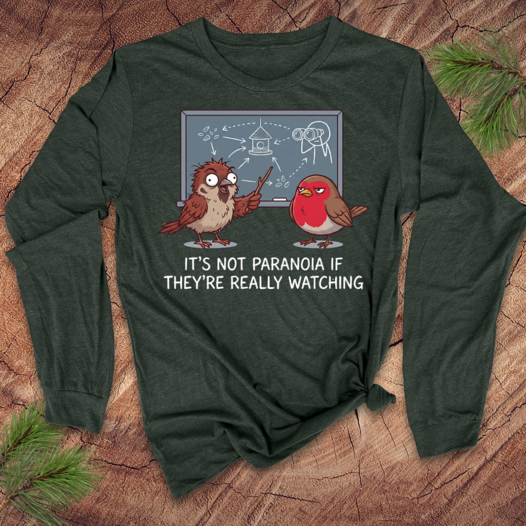 Green long-sleeve shirt with cartoon birds and text on a wooden surface