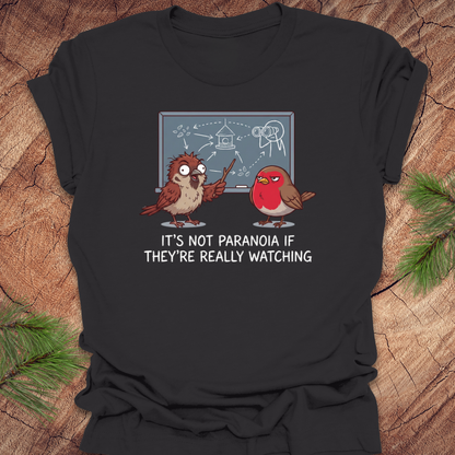 Dark gray t-shirt with cartoon birds and text on a wooden surface