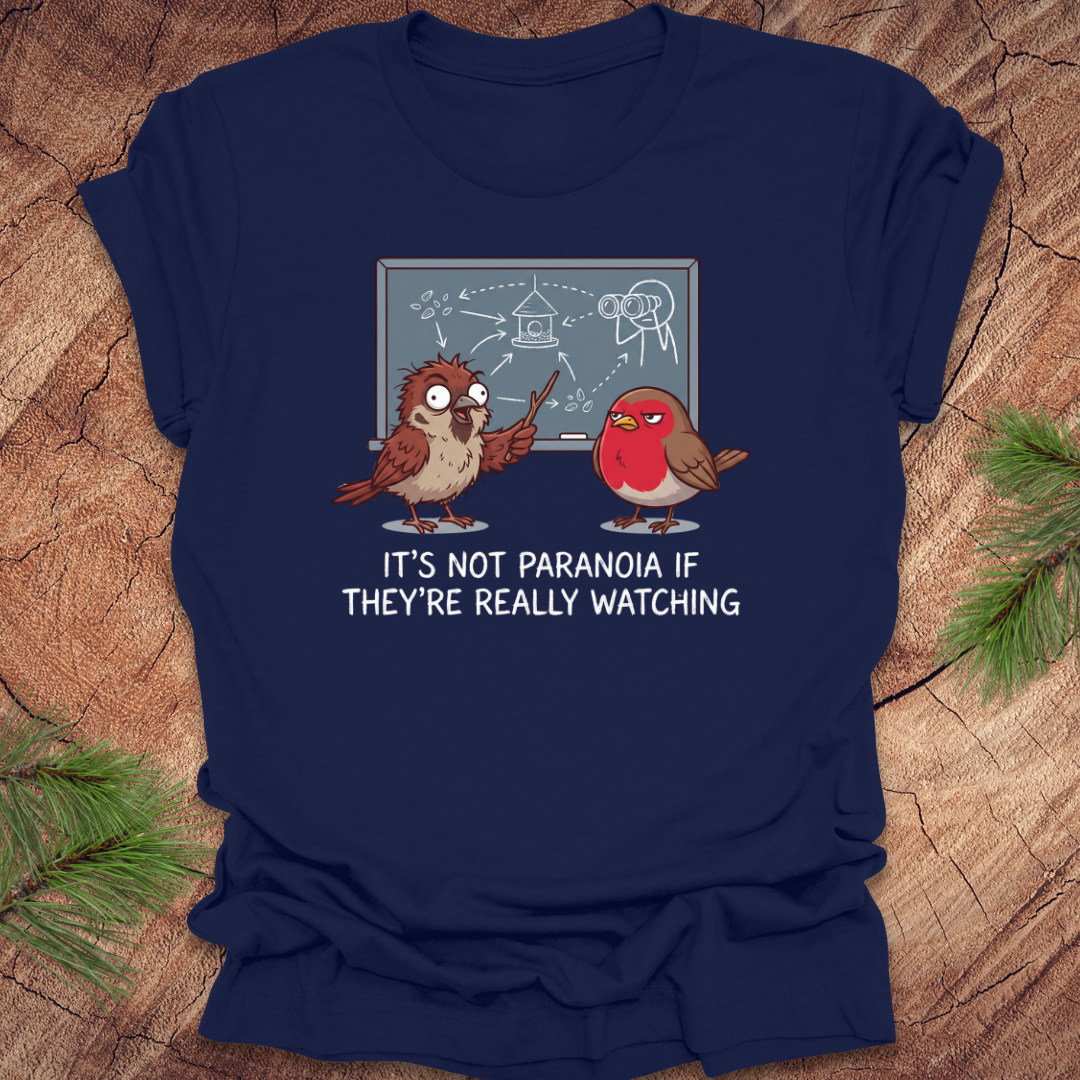 Navy blue t-shirt with cartoon birds and text on a wooden surface