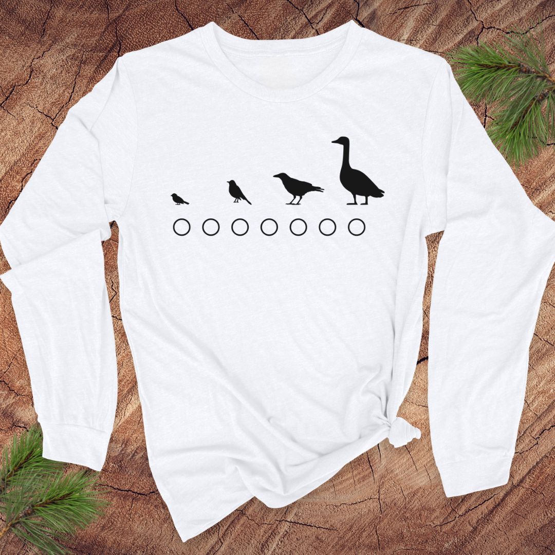 White long-sleeve shirt with black bird illustrations on a wooden surface