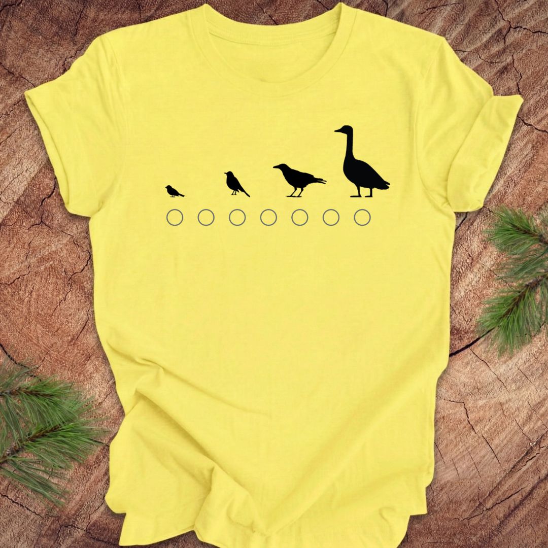 Yellow t-shirt with black bird graphic on a wooden surface