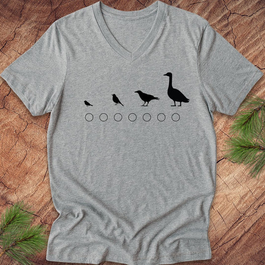Gray v-neck t-shirt with black bird illustrations on a wooden surface
