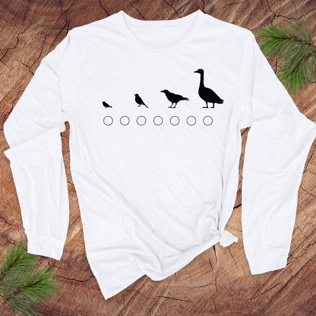 White long-sleeve shirt with black bird illustrations on a wooden surface