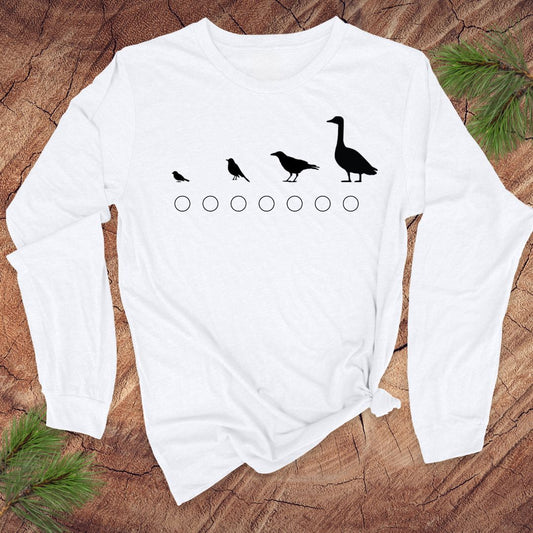 White long-sleeve shirt with black bird illustrations on a wooden surface