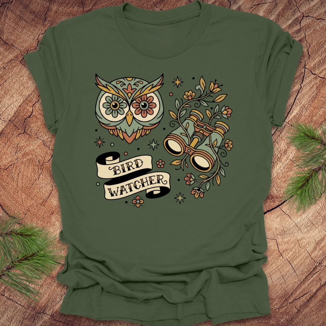 Green t-shirt with owl and binoculars design, with text 'bird watcher' on a wooden surface