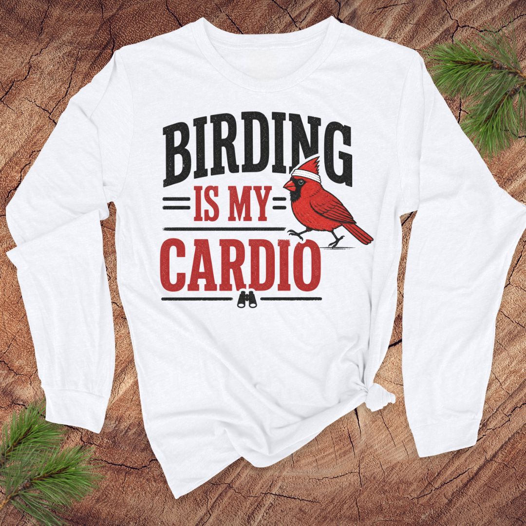 White long-sleeve t-shirt with text 'birding is my cardio' and cardinal on a wood background.