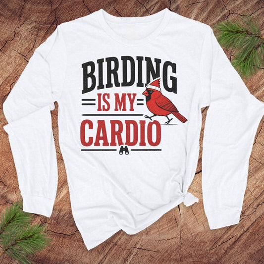 White long-sleeve t-shirt with text 'birding is my cardio' and cardinal on a wood background.