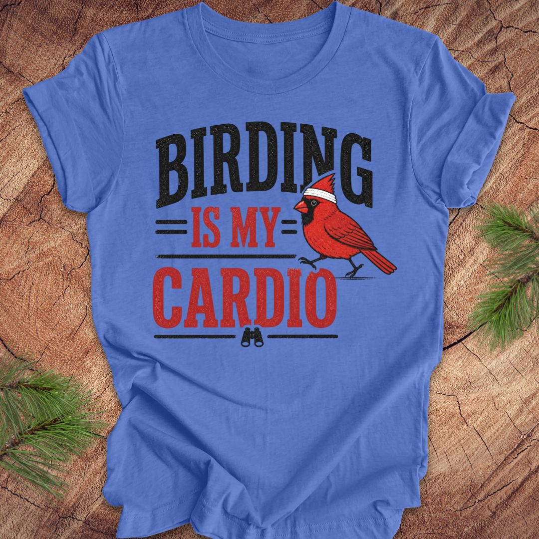 Blue t-shirt with a cardinal graphic and text 'BIRDING IS MY CARDIO' on a wooden surface.