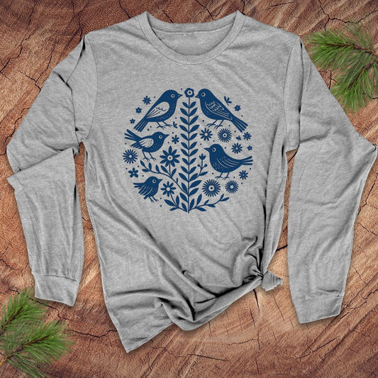 Gray long-sleeve t-shirt with blue bird and floral design on a wooden surface
