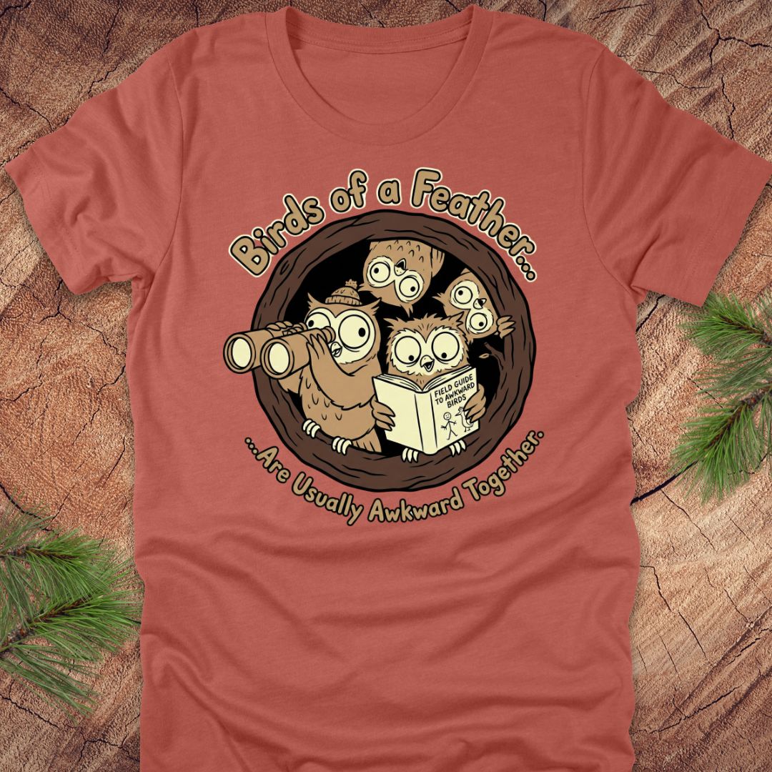 Red t-shirt with cartoon owls design on a wooden surface