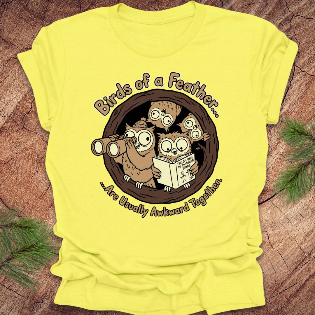 Yellow t-shirt with owl design and text on a wooden surface