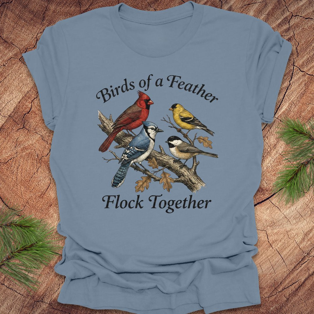 Blue t-shirt with bird design and text on a wooden surface