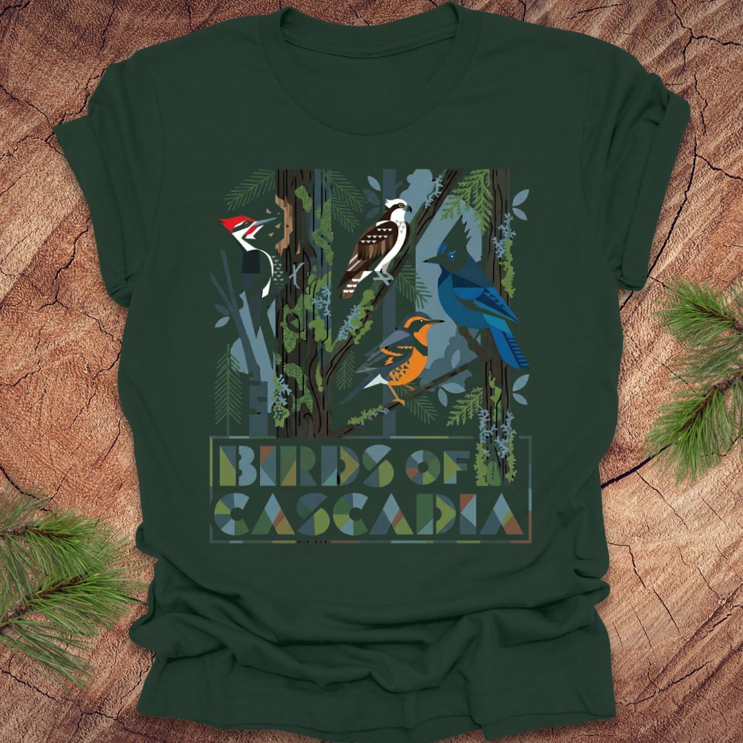 Green t-shirt with bird design and 'Birds of Cascadia' text on a wooden surface.