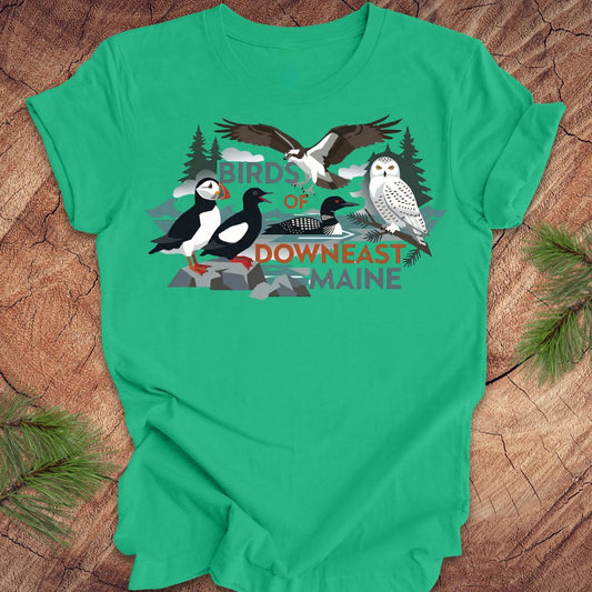 Green t-shirt with birds of downeast maine graphics and text on a wooden surface