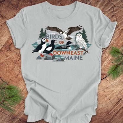 Gray t-shirt with birds of downeast maine graphics and text on a wooden surface