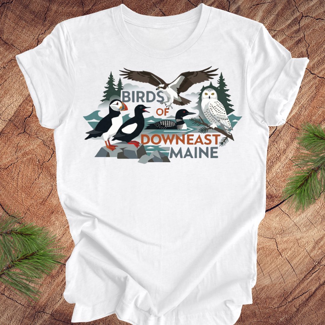 White t-shirt with birds of downeast maine graphics and text on a wooden surface