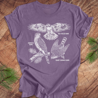 Purple t-shirt with hawk illustrations on a wooden surface