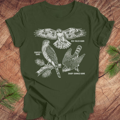 Green t-shirt with hawk illustrations on a wooden surface