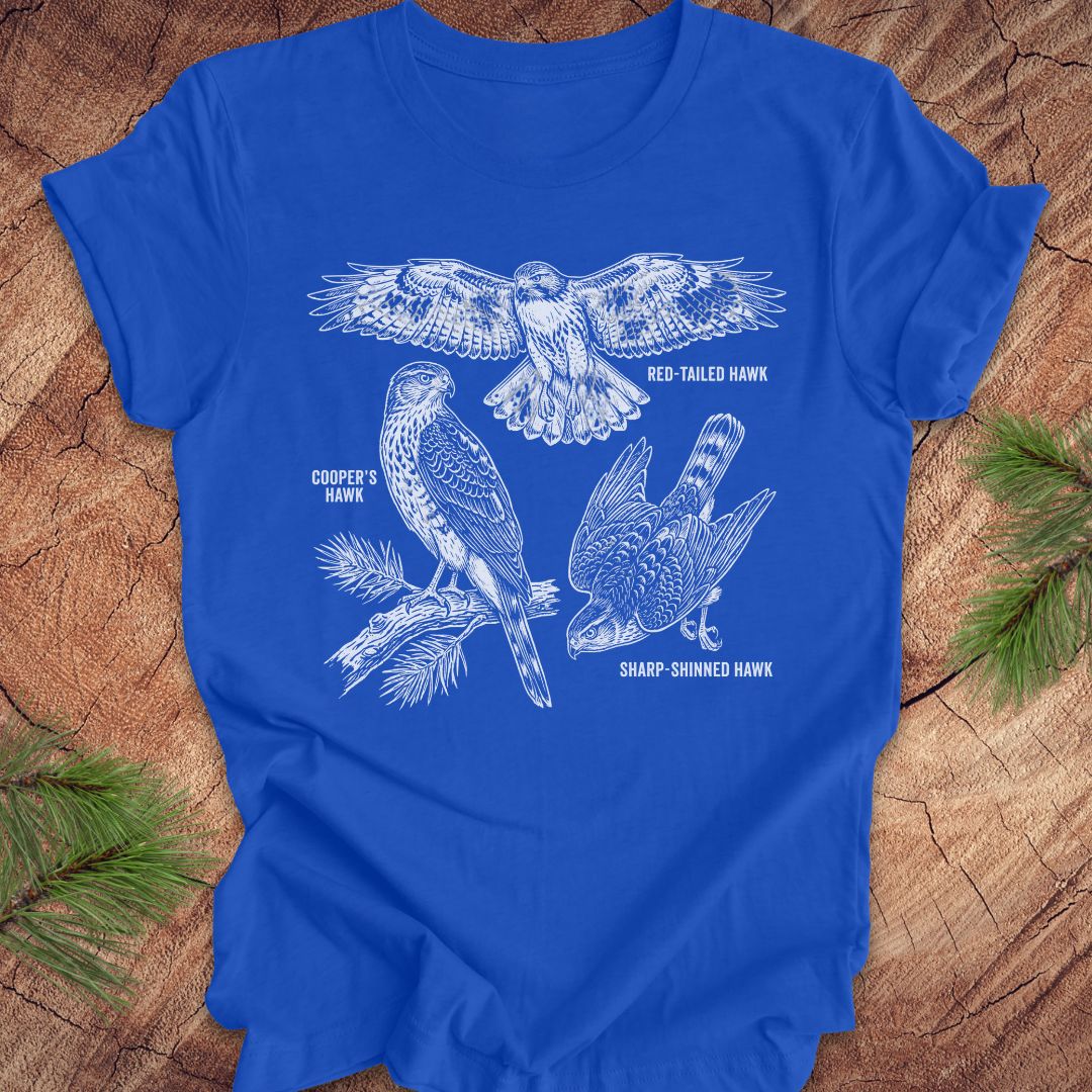 Royal blue t-shirt with hawk illustrations on a wooden surface