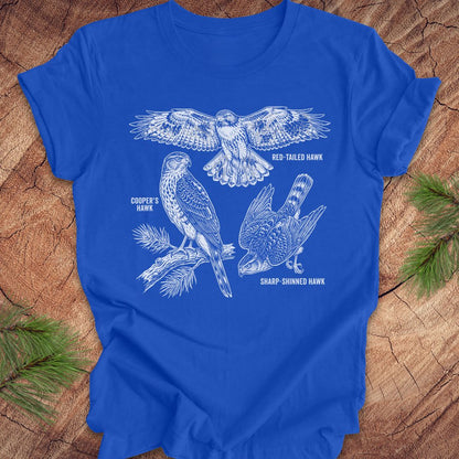 Royal blue t-shirt with hawk illustrations on a wooden surface