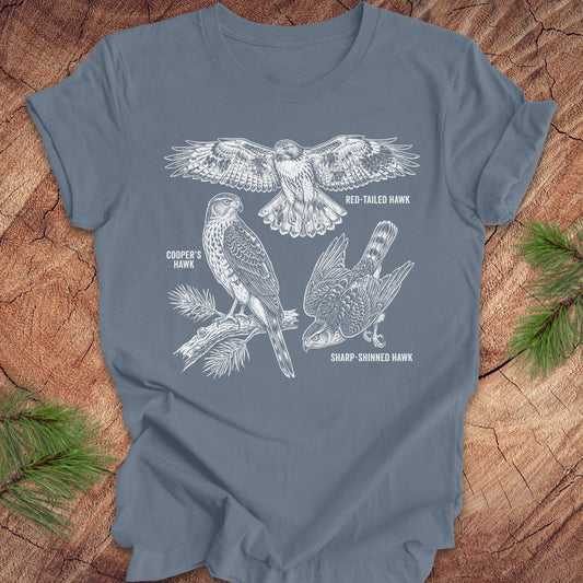 Blue t-shirt with hawk illustrations on a wooden surface