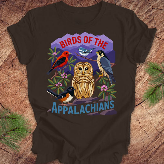 Brown t-shirt with 5 birds and text, 'birds of the appalachians' on a wood background.