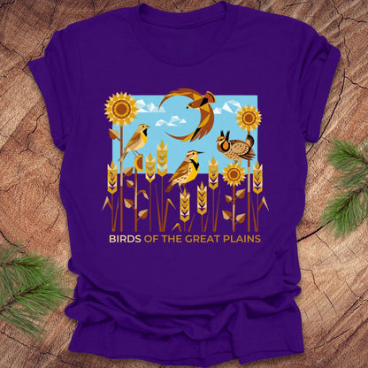 Purple t-shirt with 'Birds of the Great Plains' design featuring birds, sunflowers, and a moon on a wooden surface.