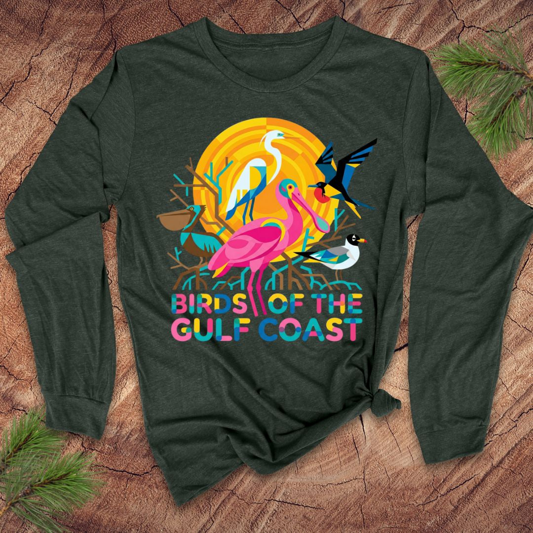 Green long-sleeve shirt with colorful bird design and 'Birds of the Gulf Coast' text on a wooden surface.