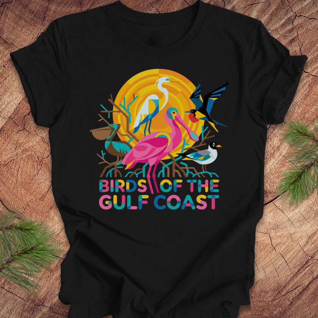 Black t-shirt with bird design and text, 'birds of the gulf coast' on a wooden background.