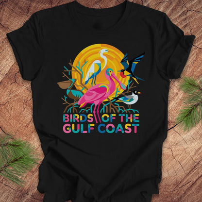 Black t-shirt with bird design and text, 'birds of the gulf coast' on a wooden background.