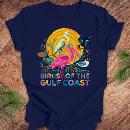 Navy blue t-shirt with bird design and text, 'birds of the gulf coast' on a wooden background.