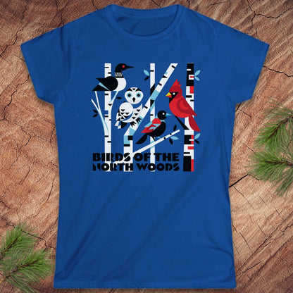 Blue t-shirt with a graphic design of birds and trees on a wooden surface.