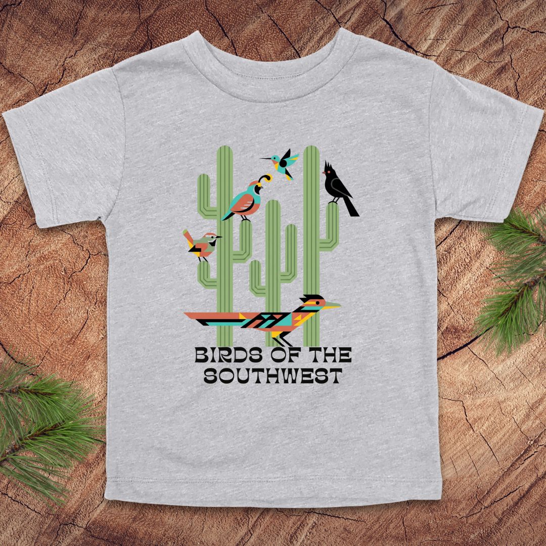 Gray toddler t-shirt with 'Birds of the Southwest' design featuring cacti and birds on a wooden surface.