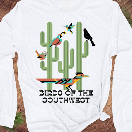A white long-sleeve t-shirt with a colorful graphic of cacti and birds, featuring the text 'BIRDS OF THE SOUTHWEST'.