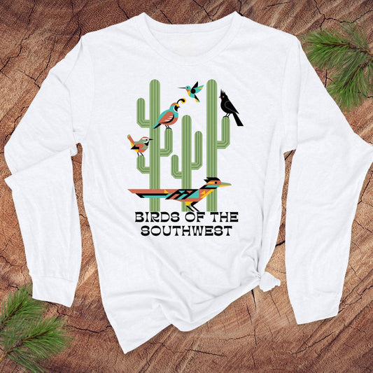 White long-sleeve tshirt with 'Birds of the Southwest' design featuring cacti and birds on a wooden surface.